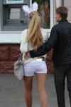 Straßenmode in Gomel. 09/2012 (Looks: hautfarbene transparente Strumpfhose, weiße Jeans-Shorts, goldener Gürtel, graue Handtasche, blonde Haare)