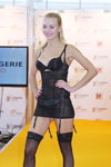 Dessous-Modenschau von Triumph — Lingerie-Expo 2013 (Looks: schwarzer BH, schwarze Halterlose Strümpfe mit Spitzenabschluss, blonde Haare, schwarzer Slip)