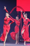 Finał — Miss Supranational 2013. Belarus Rhythmic Gymnastics (ubrania i obraz: suknia wieczorowa z rozcięciem czerwona; osoby: Ksenia Sankowicz, Natalla Leszczyk)