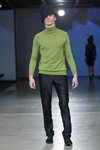 Modenschau von ALEXANDER PAVLOV — Riga Fashion Week AW13/14 (Looks: schwarzer Hut, grüner Pullover, schwarze Schnürer, schwarze Hose)