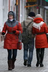 Moda en la calle en Gómel. 01/2013 (looks: abrigo rojo, vaquero azul, gorro en punto fino gris)