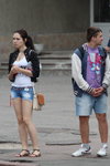 Straßenmode in Gomel. 05/2013 (Looks: weißes Top, blaue zerrissene Jeans-Shorts, schwarze Sandalen)