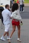 Die Straßenmode in Minsk. Der heißer Mai 2013 (Looks: rote Shorts, weiße Pumps, weiße Handtasche, weiße Bluse, kariertes Hemd, weiße Sneakers, weiße Socken)