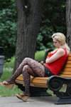 Letnia moda uliczna 2013 w Mińsku (ubrania i obraz: top czerwony, sandały na koturnie, ażurowy rajstopy czarne)