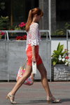 Straßenmode in Minsk. 08/2013 (Looks: weißes Top, korallenrotes anliegendes Mini Kleid, Handtasche mit Blumendruck, Pferdeschwanz (Frisur), rote Haare)