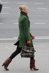 Straßenmode in Minsk. 10/2013 (Looks: grüner Mantel, braune Stiefel, rote Handschuhe, brauner Schal, schwarze Hose, karierte Handtasche, blonde Haare, Chignon)
