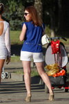 Straßenmode in Saligorsk. 06/2013 (Looks: blaues Top, weiße Shorts, weiße Handtasche, rote Haare, Sonnenbrille, hautfarbene Pumps)