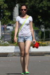 Moda uliczna w Saligorsku. 06/2013 (ubrania i obraz: top biały, jeansowe szorty błękitne, torebka sałatkowa, balerinki sałatkowe, okulary przeciwsłoneczne)