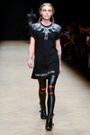 Modenschau von Karzenta. AURORA MARKET (Looks: Zopf, schwarzes bedrucktes Kleid, schwarze Stiefeletten, schwarze Leder-Leggings)