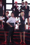 Prezentacja w stylu biznesowym w finale "Miss Białorusi 2014" (ubrania i obraz: garnitur damski (żakiet, spódnica) czarny, bluzka biała, krawat czerwony, szpilki czerwone, spodnie czarne, koszula biała, kamizelka czarna; osoba: Anastasija Kuznecowa)