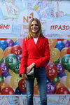 Natalja Wodianowa. Fotofakt. Natalja Wodianowa (ubrania i obraz: żakiet czerwony, jeansy niebieskie, kopertówka czarna)