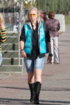 Moda uliczna w Homlu. 09/2014 (ubrania i obraz: kamizelka turkusowa pikowana, koszula czarna, jeansowe szorty, kozaki czarne, blond (kolor włosów))