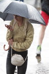 Вулична мода під дощем. Мінськ. Літо 2014 (наряди й образи: пісочна куртка, чорний парасоль, біла сумка, чорні джинси)