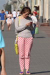 Moda uliczna w Mińsku. 08/2015 (ubrania i obraz: pulower szary, torebka żółta, spodnie w kratę różowe)