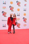 Nikolay Baskov und Sofi Kalcheva. Muz-TV Verleihung 2016 (Looks: roter Männeranzug, schwarzes Hemd, Sonnenbrille, rotes Kleid, schwarze Halterlose Strümpfe)
