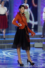 Miss Białorusi 2012 (ubrania i obraz: żakiet pomarańczowy dzianinowy, spódnica czarna, półbuty czarne)