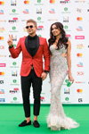 Mitja Fomin i Anzhelika Yakuseva. Ceremonia otwarcia — Nagroda Muz-TV 2017 (ubrania i obraz: okulary przeciwsłoneczne, koszula czarna, marynarka czerwona, spodnie czarne, suknia wieczorowa biała)