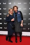 Goście — Riga Fashion Week AW17/18 (ubrania i obraz: sukienka niebieska, torebka czarna, kozaki czarne, kamizelka jeansowa niebieska, sukienka szara)
