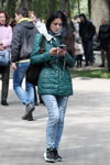 Moda uliczna w Homlu. Zimny maj (ubrania i obraz: kurtka pikowana morska, jeansy z podartymi nogawkami błękitne, buty sportowe czarne)