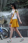 Moda uliczna w Soligorsku. Gorący maj (ubrania i obraz: top z nadrukiem biały, spódnica mini żółta, torebka żółta, sandały na koturnie turkusowe, cienkie rajstopy cieliste)