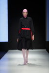 Pokaz Talented — Riga Fashion Week AW18/19 (ubrania i obraz: sukienka czarna, pasek czerwony, cienkie rajstopy białe)