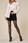 Kampania limitowanej kolekcji pończoszniczej "Femmes" od Fiore (ubrania i obraz: bluzka biała, spódnica mini czarna, rajstopy czarne, półbuty czarne)