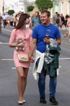 Ciepły wrzesień 2018. Moda uliczna w Homlu (ubrania i obraz: sukienka mini różowa, rajstopy cieliste, balerinki beżowe, torebka beżowa, koszulka niebieska, jeansy niebieskie, buty sportowe czarne)