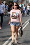 Ciepły wrzesień 2018. Moda uliczna w Homlu (ubrania i obraz: okulary przeciwsłoneczne, top z nadrukiem różowy, jeansowe szorty błękitne, balerinki szare)