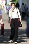 Gorący maj 2018. Moda uliczna w Mińsku (ubrania i obraz: bluzka biała, torebka czarna, spodnie z lampasami czarne, buty sportowe białe)