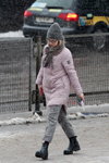 Street fashion under the snowfall. December 2018 in Minsk (looks: lilac jacket, grey checkered trousers, black boots, grey scarf, grey knit cap)