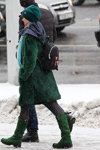 Street fashion under the snowfall. December 2018 in Minsk (looks: green coat, black backpack, black tights, green boots, aquamarine knit cap)