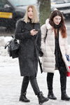 Moda uliczna pod śniegiem. Grudzień 2018 w Mińsku (ubrania i obraz: palto czarne, torebka czarna, botki czarne, skórzane spodnie czarne, palto białe pikowane)
