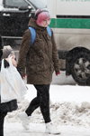 Street fashion under the snowfall. December 2018 in Minsk (looks: brown jacket, white sneakers)