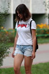 Sierpień 2018. Moda uliczna w Soligorsku (ubrania i obraz: top z nadrukiem biały, jeansowe szorty błękitne)