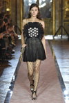 Greta Varlese. Pokaz Giambattista Valli x H&M (ubrania i obraz: suknia koktajlowa czarna, rajstopy z siatki o dużym oku czarne, sandały czarne)