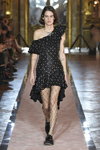 Miriam Sanchez. Pokaz Giambattista Valli x H&M (ubrania i obraz: suknia koktajlowa czarna, półbuty czarne, rajstopy z siatki o dużym oku czarne)