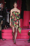 Alicja Tubilewicz. Pokaz PERTEGAZ — MBFW Madrid FW20/21 (ubrania i obraz: suknia koktajlowa zielona kwiecista, cienkie rajstopy czarne, półbuty czerwone)