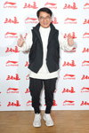 Jackie Chan. Modenschau von Li-Ning — Paris Fashion Week (Men) FW 20/21 (Looks: schwarze Weste, graue Sneakers, weißer Kapuzenpullover)
