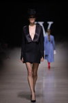 Pokaz IVETA VECMANE — Riga Fashion Week SS2021 (ubrania i obraz: sukienka żakiet czarna, rajstopy w siatkę czarne, półbuty czarne)