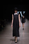 Pokaz IVETA VECMANE — Riga Fashion Week SS2021 (ubrania i obraz: kapelusz czarny, sukienka czarna, rajstopy w siatkę czarne)