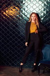 Orsay FW 19/20 campaign (looks: black pantsuit, orange top, black lowboots)