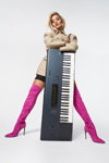 Rita Ora. ShoeDazzle x Rita Ora campaign (looks: fuchsia knee high boots, beige coat, blond hair)