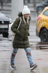 Minsk street fashion. 02/2020 (looks: khaki quilted coat, white backpack, sky blue ripped jeans, white knit cap, white knit cap with pom-pom, blond hair)