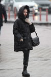 Straßenmode in Minsk. 02/2020 (Looks: schwarzer gesteppter Mantel, schwarze Hose, schwarze Handtasche)