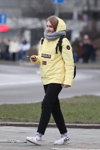 Straßenmode in Minsk. 02/2020 (Looks: gelbe Jacke, schwarze Hose, weiße Sneakers, grauer Schal)