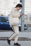 Moda uliczna w Mińsku. 03/2020 (ubrania i obraz: kurtka biała, spodnie sportowe beżowe, buty sportowe czarne)