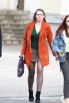 Moda uliczna w Mińsku. 03/2020 (ubrania i obraz: spódnica mini szara, cienkie rajstopy czarne, botki czarne, pulower zielony, palto koralowe)