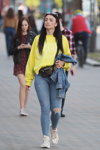 Moda uliczna w Mińsku. 05/2020. Część 3 (ubrania i obraz: pulower żółty, jeansy z podartymi nogawkami błękitne, buty sportowe białe)