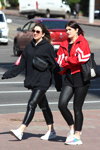 Moda en la calle en Minsk. 05/2020. Parte 7 (looks: sudadera con capucha negra, pantalón de piel negro, sneakers blancos, chaqueta de deporte roja, top negro, leggings negros, sneakers blancos)