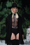 Amoralle lingerie show — Riga Fashion Week SS2022 (looks: black transparent bodysuit, black hat, blond hair)